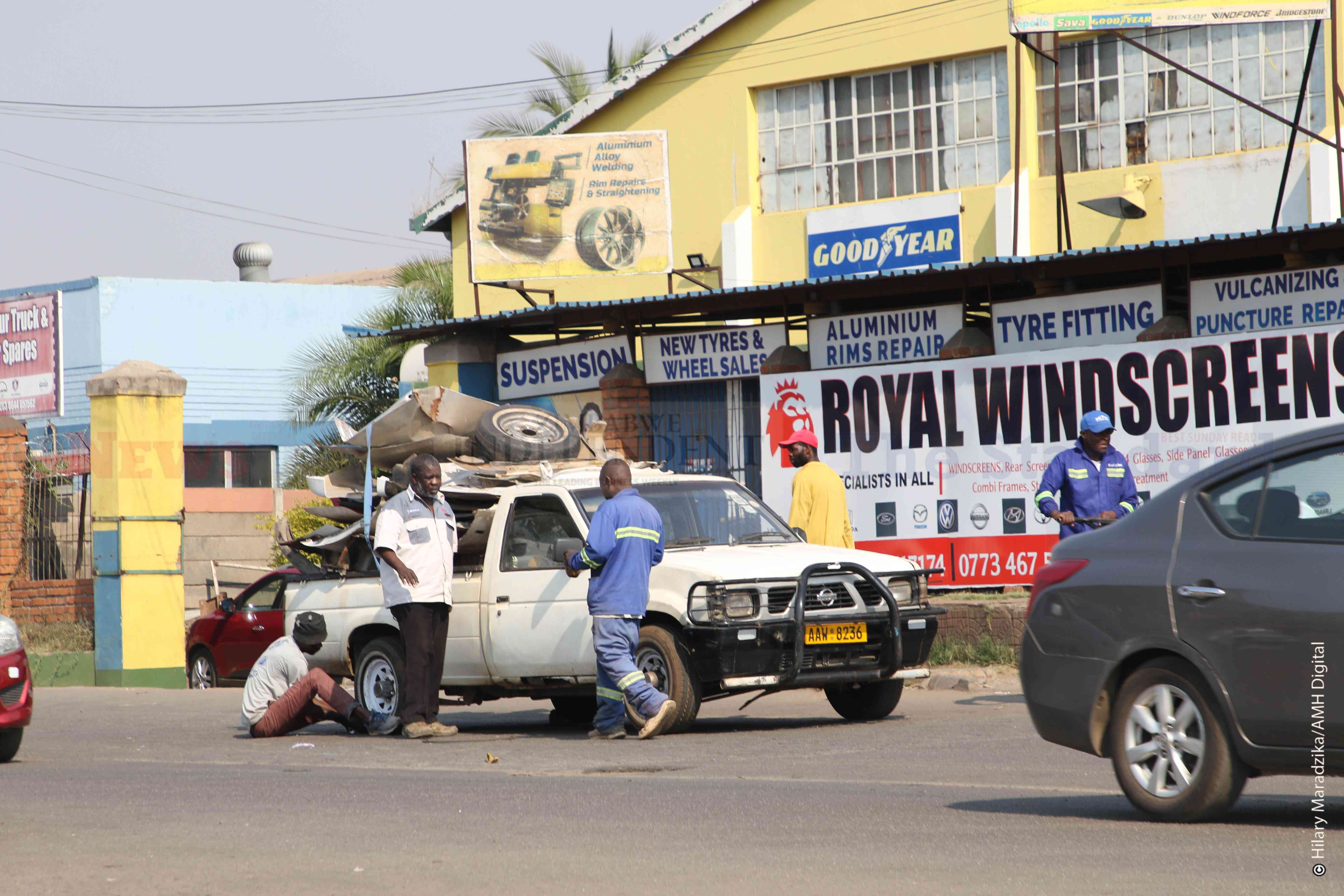 Unidentified men attend to a car break down in Graniteside, Harare
